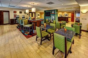 um restaurante com mesas e cadeiras e um bar em Hampton Inn Manning em Manning