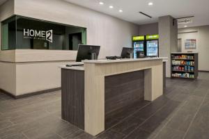 a lobby of a store with two laptops on a counter at Home2 Suites By Hilton Rowlett Rockwall Marina in Rowlett +14 photos
