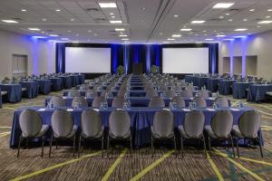 ein Konferenzraum mit blauen Tischen und Stühlen in der Unterkunft Dellagio Hotel in Wa