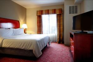 a hotel room with a bed and a flat screen tv at Hilton Garden Inn Elkhart in Elkhart