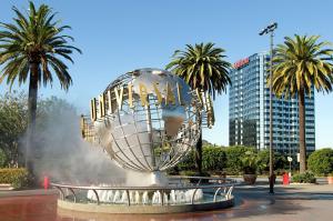 a large metal sphere in a fountain with palm trees at Hilton Los Angeles-Universal City in Los Angeles