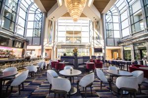 a restaurant with tables and chairs in a building at Hilton Los Angeles-Universal City in Los Angeles