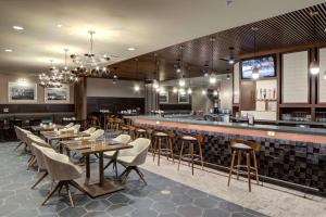 a restaurant with tables and chairs and a bar at Doubletree by Hilton Harrisonburg in Harrisonburg