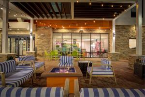 レイクチャールズにあるHome2 Suites By Hilton Lake Charlesの青と白の椅子とファイヤーピットのあるロビー