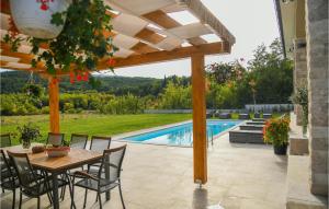 a patio with a table and chairs and a pool at Villa Raviola in Sinj