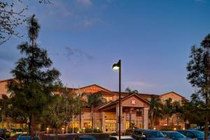 un gran edificio con coches estacionados frente a él en Hilton Garden Inn San Bernardino, en San Bernardino