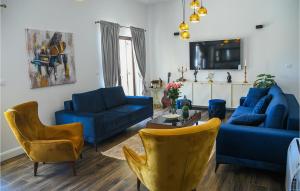 sala de estar con sofás azules y TV en Villa Raviola, en Sinj