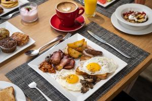 uma mesa com um prato de comida para o pequeno-almoço e uma chávena de café em Protea Hotel Fire & Ice by Marriott Cape Town em Cidade do Cabo