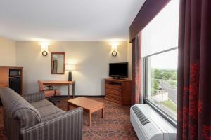 een hotelkamer met een bank en een televisie bij Hampton Inn Branson on the Strip in Branson