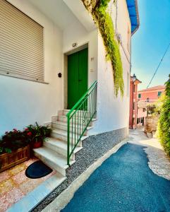 a green door on the side of a building with stairs at La casa dei nonni in Moneglia