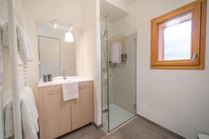 een badkamer met een douche, een wastafel en een spiegel bij Studio au cœur du village in Saint-Jean-de-Sixt