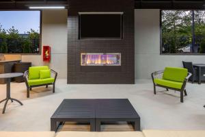 a lobby with two green chairs and a fireplace at Hampton Inn & Suites Alpharetta Roswell in Alpharetta