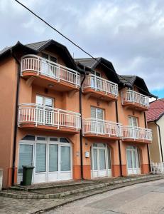 a orange house with balconies on the side of it at Deutsches Haus Livno in Livno