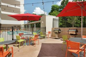 een patio met tafels en stoelen en een zwembad bij Home2 Suites by Hilton Durham Chapel Hill in Durham