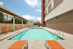 - une piscine sur le côté d'un bâtiment dans l'établissement Home2 Suites by Hilton Durham Chapel Hill, à Durham