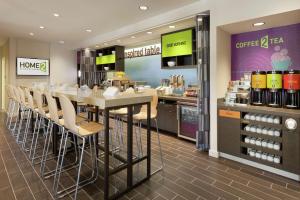 Home2 Suites by Hilton Durham Chapel Hill في دورهام: مطعم فيه طاولة وكراسي في محل