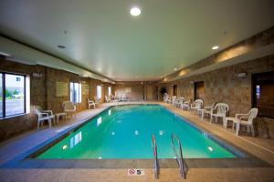 a pool in a hotel with chairs and tables at Hampton Inn & Suites by Hilton Seattle/Kent in Kent