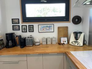 a kitchen counter with a coffee maker and a tv at Gîtes d Izel N1 entre terre et mer prés d'un golf in Ploemel