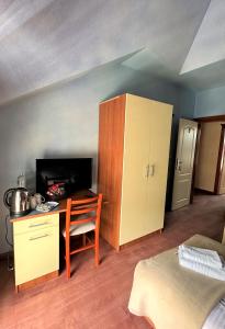 een kamer met een bureau, een kast en een bed bij Deutsches Haus Livno in Livno