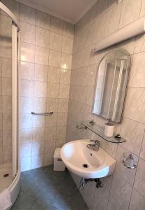 een witte badkamer met een wastafel en een spiegel bij Deutsches Haus Livno in Livno