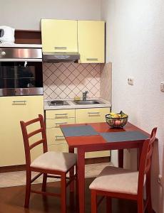 een keuken met een tafel, 2 stoelen en een wastafel bij Deutsches Haus Livno in Livno