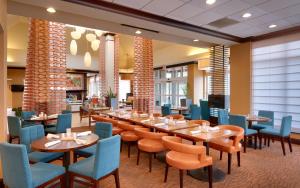 un restaurante con mesas de madera y sillas azules en Hilton Garden Inn Clarksville, en Clarksville