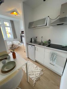 a white kitchen with a sink and a table at St Catherine in Liège +34 photos