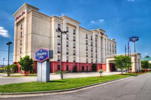 a large white building with a sign in front of it at Hampton Inn Roanoke Rapids in Roanoke Rapids