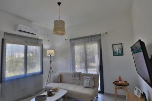 a living room with a couch and two windows at Stunning Seaview Haven 3 min to Beach in Lapta in Kyrenia