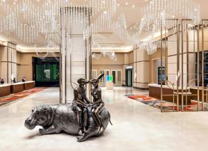 a statue of a woman sitting on a dog in a lobby at Crockfords Las Vegas, LXR Hotels & Resorts at Resorts World in Las Vegas