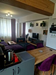 a living room with a table and purple chairs at Casa Mov in Braşov