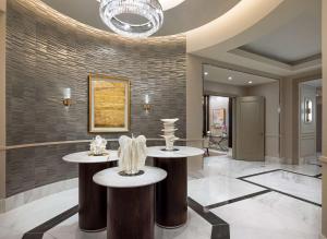 拉斯维加斯Crockfords Las Vegas, LXR Hotels & Resorts at Resorts World的大堂设有两张桌子,上面有花瓶