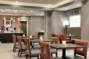 a restaurant with tables and chairs and a counter at Hampton Inn By Hilton North Olmsted Cleveland Airport in North Olmsted