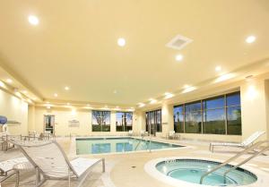 a large house with a swimming pool and chairs at Embassy Suites Palmdale in Palmdale