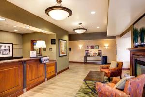 a lobby with a fireplace and a living room at Hampton Inn & Suites Addison in Addison