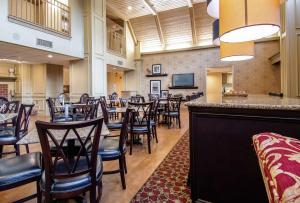 a restaurant with tables and chairs and a bar at Hampton Inn & Suites Williamsburg-Richmond Road in Williamsburg