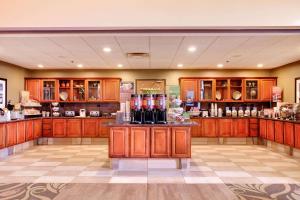 a large kitchen with wooden cabinets and bottles of wine at Hampton Inn & Suites Addison in Addison