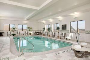 a pool in a hotel with chairs and a table at Hampton Inn & Suites Addison in Addison