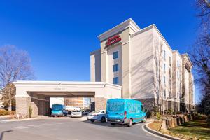 a blue van parked in front of a building at Hampton Inn & Suites Charlotte-Airport in Charlotte