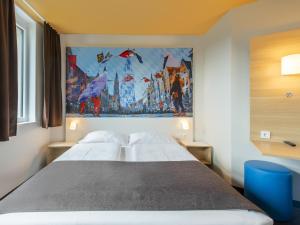 Ce lit se trouve dans un dortoir orné d'une peinture murale. dans l'établissement B&B Hotel Landshut, à Landshut