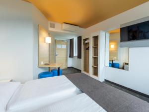 ランツフートにあるB&B Hotel Landshutのベッドとデスクが備わるホテルルームです。