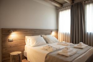 a bedroom with a bed with towels on it at Corte Grisela Wine&Relax in Monteforte dʼAlpone