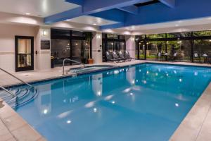 ein großer Pool mit blauem Wasser in einem Hotel in der Unterkunft Hilton Garden Inn Detroit Southfield in Southfield