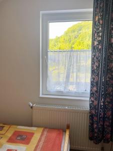 een slaapkamer met een raam en een bed ervoor bij Kati Guesthouse in Corund