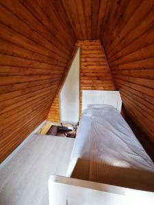 a bed in a room with a wooden ceiling at Livada Becica in Cărbunari