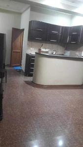 an empty room with a kitchen with black cabinets at House in Batumi in Batumi