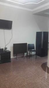 a living room with a flat screen tv and two chairs at House in Batumi in Batumi