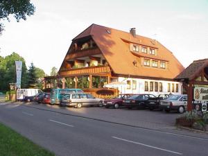 un gran edificio con coches estacionados frente a él en See-Hotel Storchenmuehle en Fichtenau