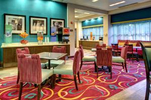 a restaurant with tables and chairs on a rug at Hampton Inn Miami-Coconut Grove/Coral Gables in Miami