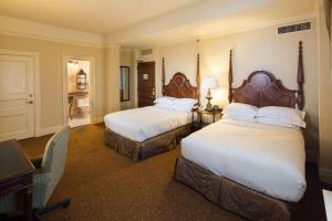 a hotel room with two beds and a desk at The Seelbach Hilton Louisville in Louisville